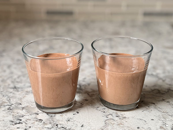 Serving glasses filled with chocolate orange mousse.