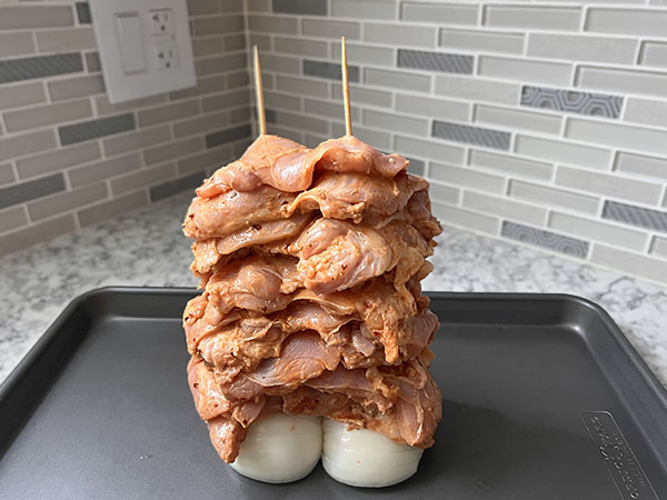 Маринованные кусочки курицы, нанизанные на шмажки в форме башни.