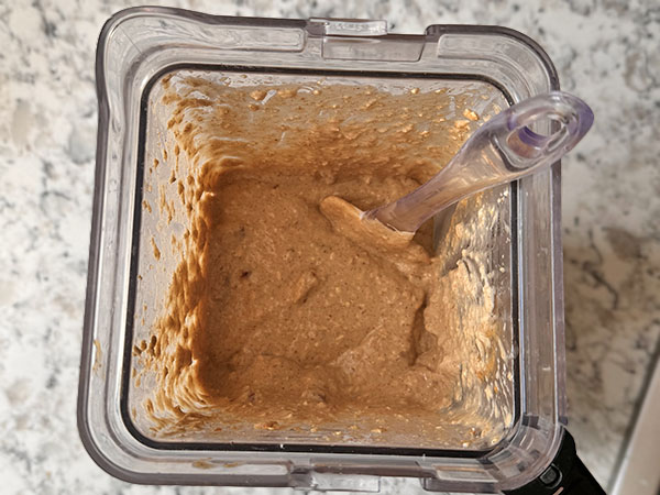 Gluten free muffin batter in a blender with a spatula.