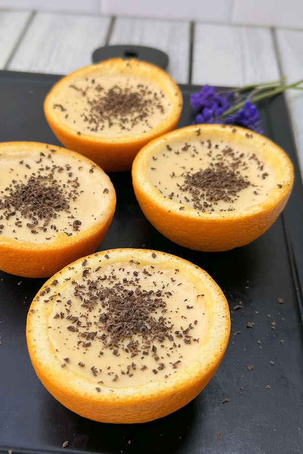 Orange Custard Dessert Cups topped with chocolate shavings on a serving board.