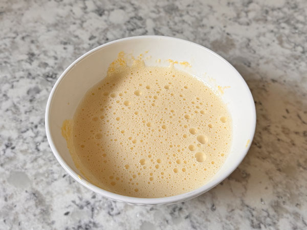 Powdered sugar and egg yolks mixture in a bowl.
